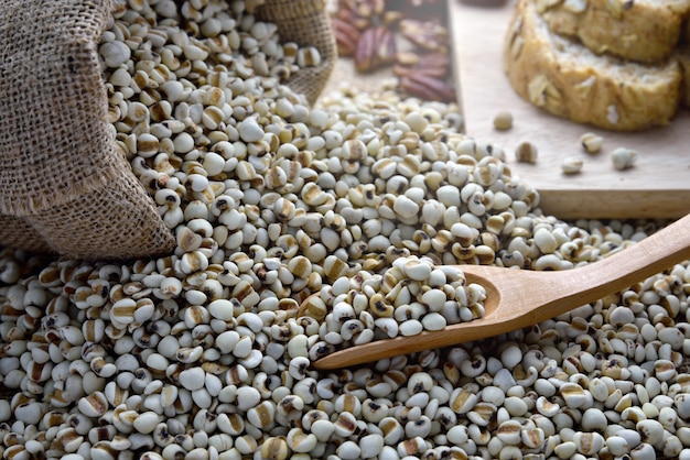 Millet bean in burlap sack with wooden spoon which has bread placed on side,