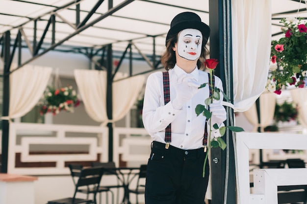 Mime looking to a red rose