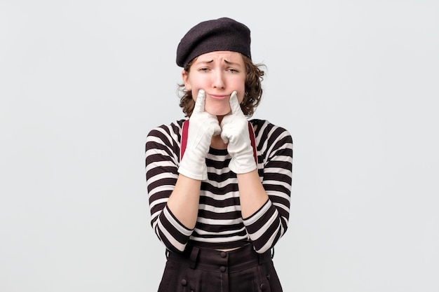 Mime making fake smile with her fingers stretching the corners of her mouth