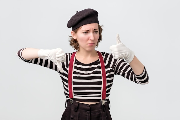 Mime making good or bad sign showing thumb up making a choice