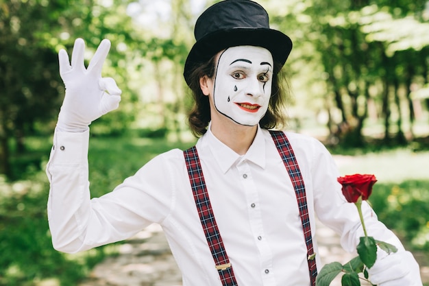 Mime with red rose in a park