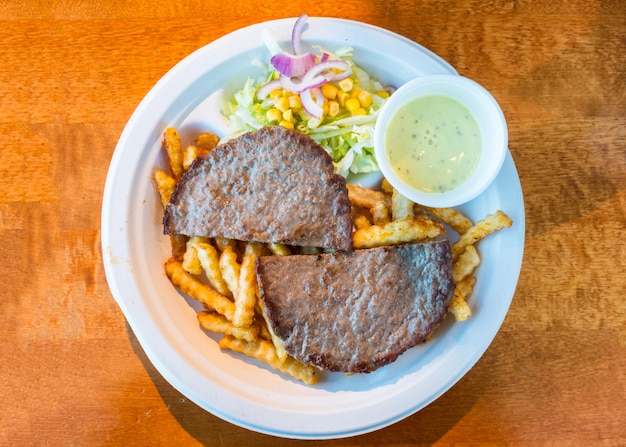 Minced beef grilled sliced with potato vegetable and sauce on plate