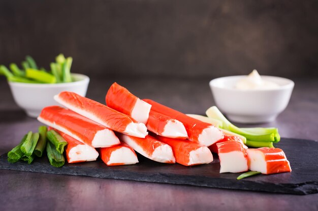 Minced fish crab sticks and green onions on a stone board ready to eat