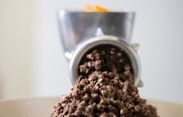 Minced meat in a manual mechanical meat grinder Fresh boiled meat is ground with an old metal