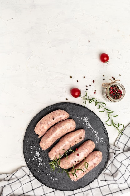 Minced meat wrapped in bacon on a light background chevapchichi or Kofta kebab raw sausages of ground beef or pork with onions and spices wrapped in bacon vertical image top view place for text