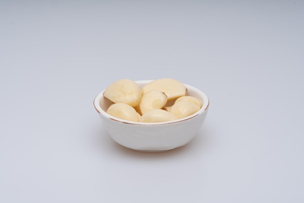 Minced and peeled garlic on a white background