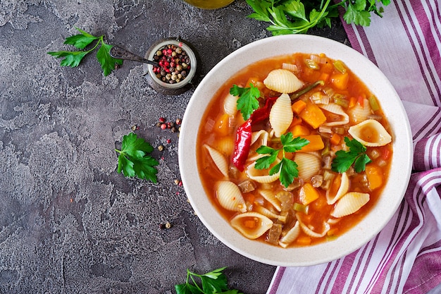 Minestrone, italian vegetable soup with pasta on  table. Vegan food. Top view