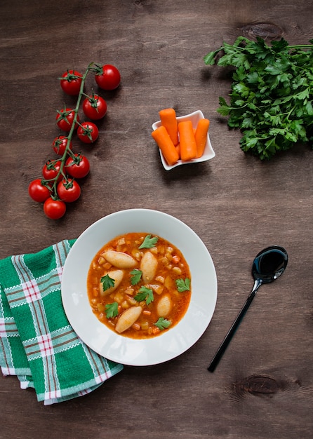 Photo minestrone soup with pasta and herbs. italian cuisine. dark wooden background