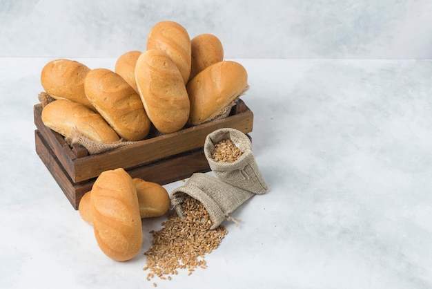 Mini Baton bread in wood box composition on white background