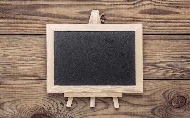 Mini blackboard on wooden table Empty blank chalkboard with copy space Business education learning concept