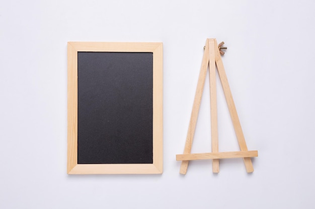 Mini blank chalk board and tripod on white background