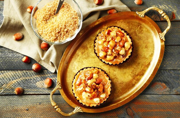 Photo mini cakes with nuts on napkin on wooden background