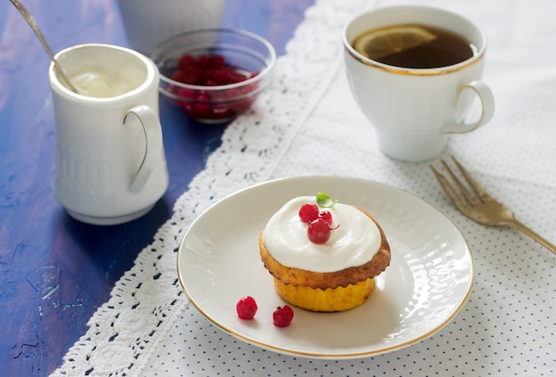 Mini cheesecake with whipped cream and red currant. Rustic style.