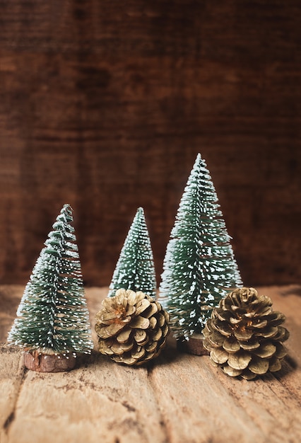 Mini christmas tree and pine cone wood on rustic wooden table 