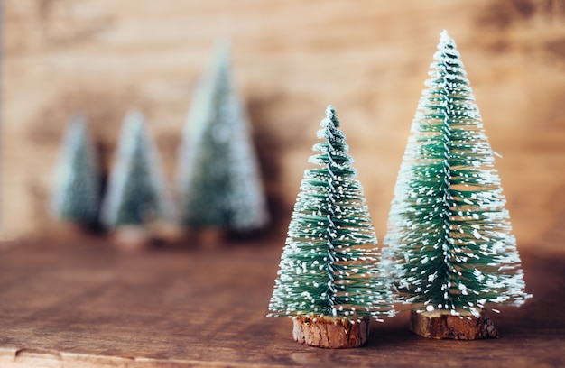 Mini christmas tree wood on rustic wooden table and dark brown hardwood wall