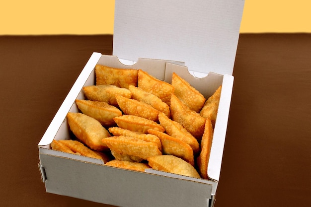 mini fried pastries in paper packaging box for delivery