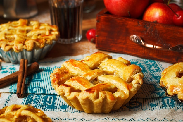 Mini homemade apple pies on rustic wood with coffee