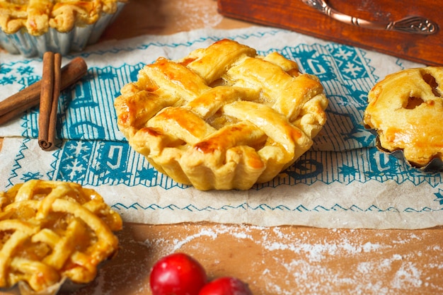 Mini homemade apple pies on rustic wood with coffee