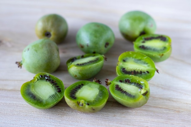 Mini kiwi actinidia on wooden board cut in half selective focus