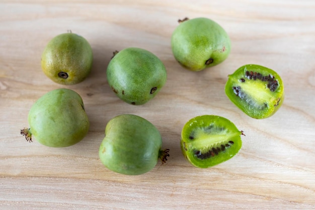 Mini kiwi actinidia on a wooden board A cut up little fruit Selective focus