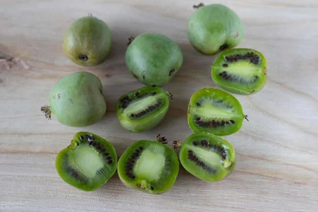 Mini kiwi actinidia on a wooden board A cut up little fruit Selective focus