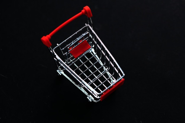 Mini red shopping cart shop concept Empty top view mini shopping cart or trolley shopping on black background concept shopping in supermarket