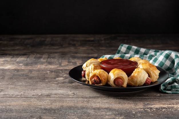 Mini sausages wrapped in puff pastry with ketchup sauce