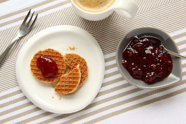 Mini stroopwafels syrupwaffles with cup of coffee and jam