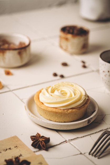 Mini tart with whipped cream and lemon sweet dessert on white plate