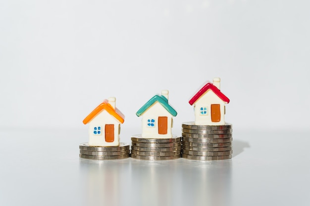 Miniature colorful house on stack coins isolated on white background 