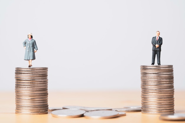 Photo miniature figure of businessman standing on equal coins stacking of  businesswoman for equality of gender male and female of income and salary concept.