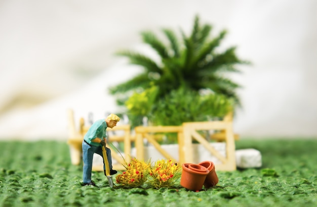 miniature figure man planting tree gardening planting concept