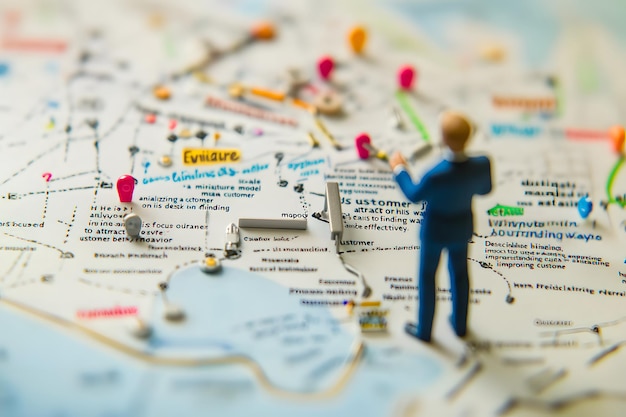 Photo miniature figure presenting a business strategy on a handwritten map