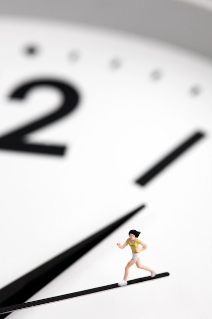 Photo miniature girl running on second hand clock