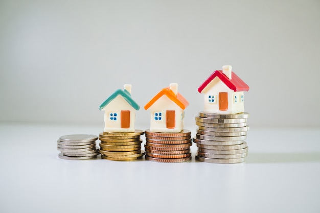 Miniature house on stack of coins