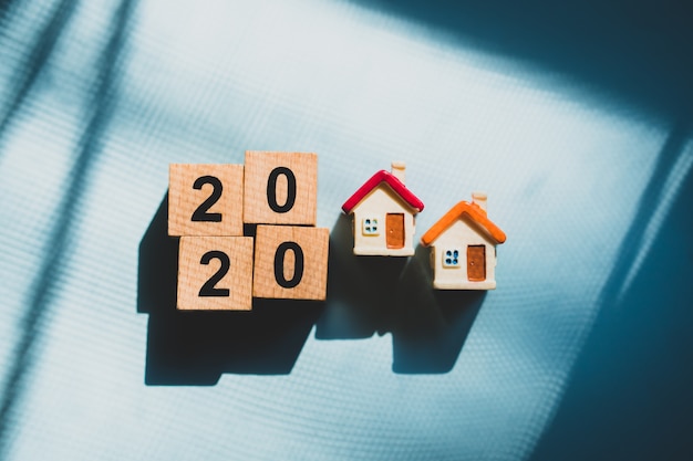 Miniature house with year 2020 in wooden blocks