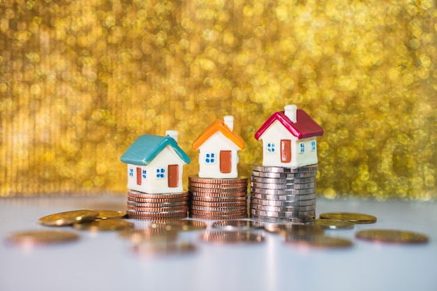 Miniature houses standing on stack coins