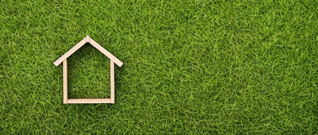 Miniature model of a wooden house on a meadow the concept of suburban real estate in the village