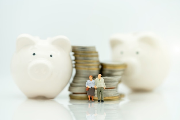 Miniature of Old people standing with coins stack and Piggy bank