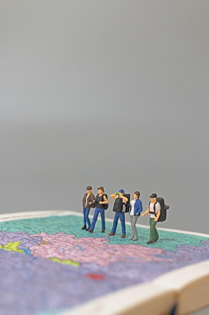 Photo miniature people backpacker walking on map