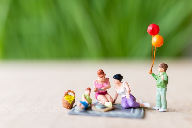 Miniature people , A beautiful couple of lesbian ladies having fun in the park with children