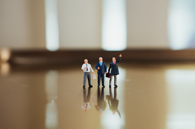 Miniature people, business team standing action using as business corporation concept