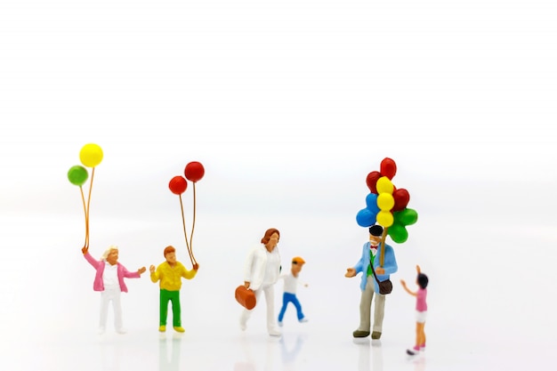 Miniature people children holding balloon with sunlight