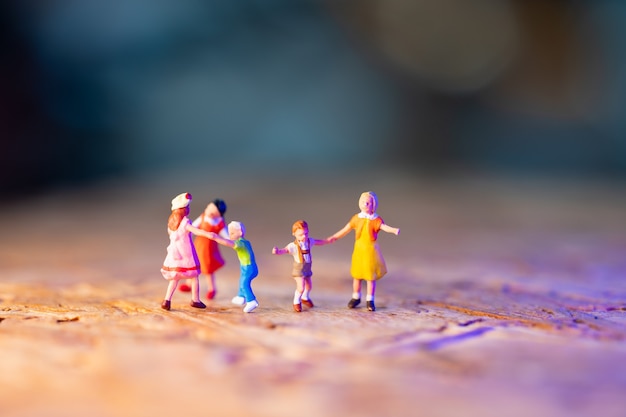 Miniature people, children playing on ground using as family and education concept