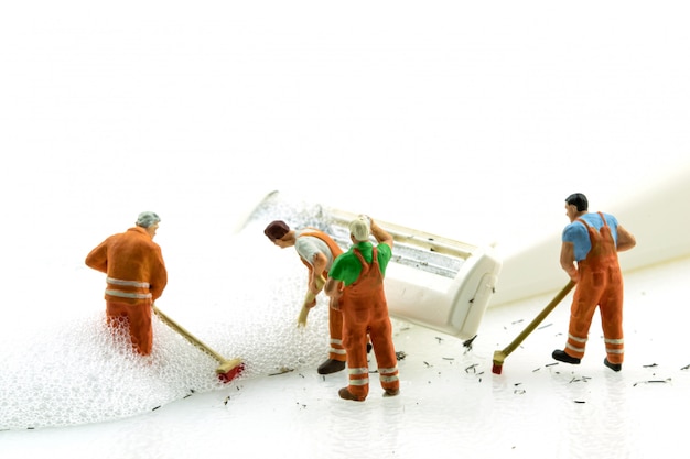 Miniature people cleaning dirty white shaver on white background.