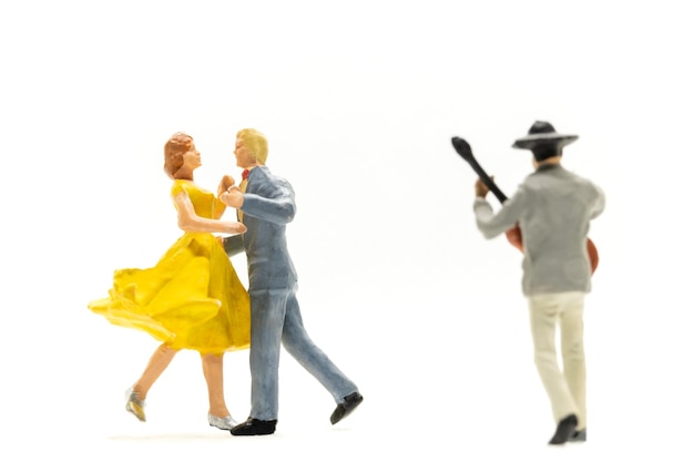 Miniature people Couple dancing with a guitarist playing the guitar