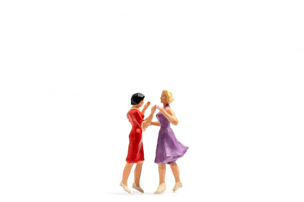 Miniature people dancing on white