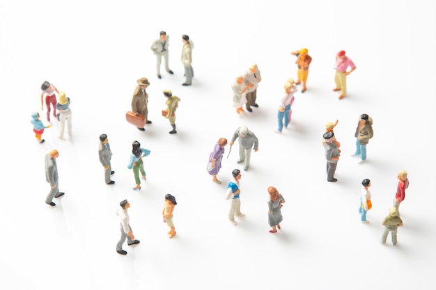 Miniature people different people stand on a white background communication of society of different generations