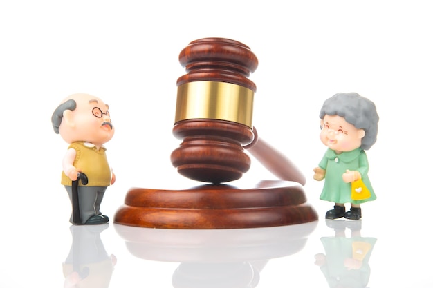 Miniature people Elderly couple of people near the gavel of law and justice Laws to ensure the life of pensioners