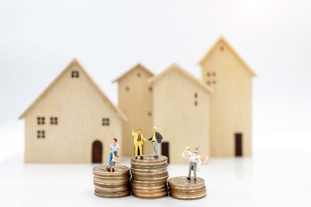 Miniature people: Elderly person standing on coins stack with home, Retirement planning concept.